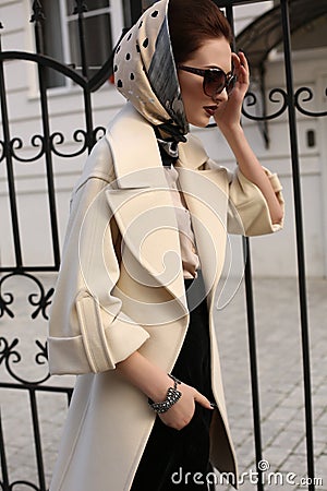 Beautiful woman in elegant coat and silk scarf on head Stock Photo