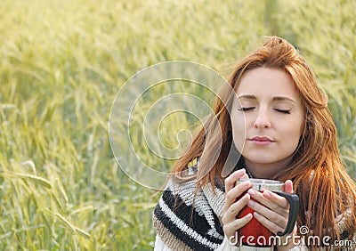 Beautiful woman enjoying hot drink in autumn cold day Stock Photo