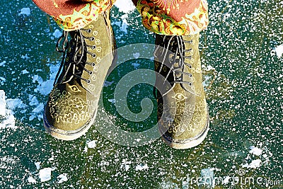 Beautiful woman ethno shoes on ice lake. Blue color background. Stock Photo