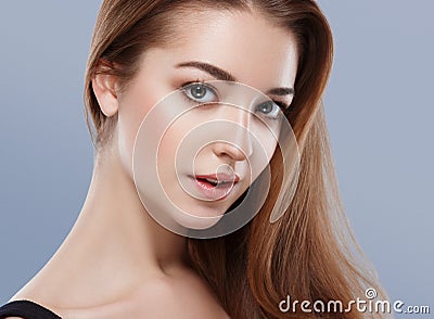 Beautiful woman face close up portrait young studio on blue Stock Photo