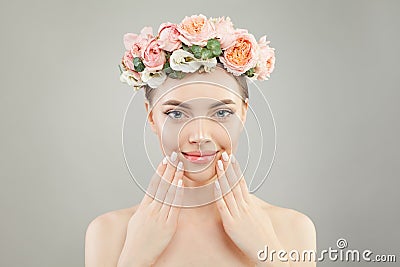 Beautiful woman face. Spa model girl with clear skin, hand with manicured nails and roses flowers on head Stock Photo