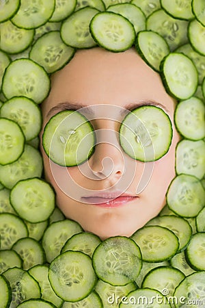 Beautiful woman with facial mask of cucumber slices on face Stock Photo