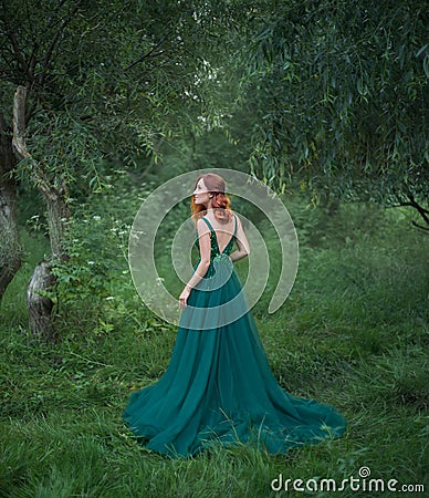 Beautiful woman in the forest is standing with her back to the camera. Stock Photo