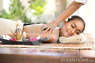 Beautiful woman getting spa hot stones massage in spa salon Stock Photo