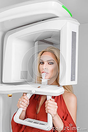 Beautiful woman in a dental office. The dentist makes dental X-rays. Teeth whitening. Stock Photo