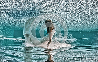 Beautiful woman girl dress underwater diving swim blue sunny day pool Stock Photo