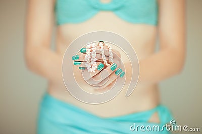 Beautiful woman hands with perfect blue nail polish holding coral necklace, happy bikini beach mood Stock Photo