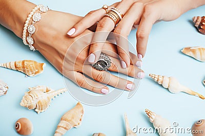 Beautiful woman hands with pink manicure holding plate with pearls and sea shells, luxury jewelry concept Stock Photo