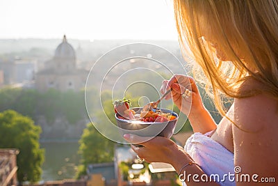 Woman having delicious healthy breakfast on terrace in city Stock Photo