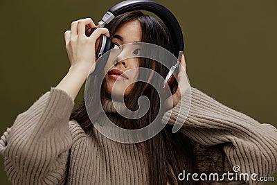 beautiful woman in headphones listening to music emotions Green background Stock Photo