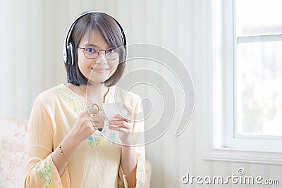 Beautiful woman with headphones and smartphone relaxing on Stock Photo