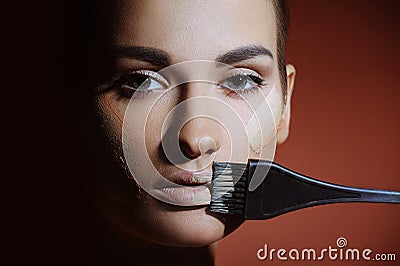 Beautiful woman with health fresh skin applying female makeup cream on lips Stock Photo