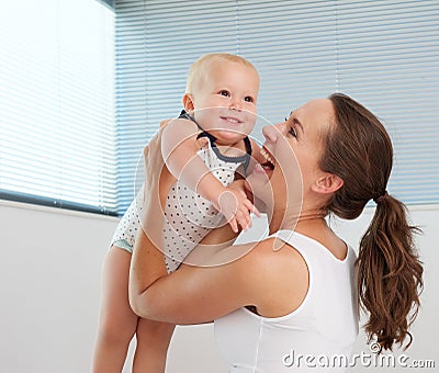 Beautiful woman holding cute smiling baby Stock Photo