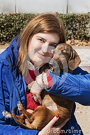Beautiful woman holding her dachshund at the park Stock Photo