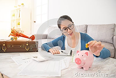 Woman savings gold coins to the piggy to travel Stock Photo