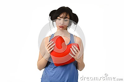 Beautiful woman hurt and suffering for lost love holding red heart shape pillow Stock Photo