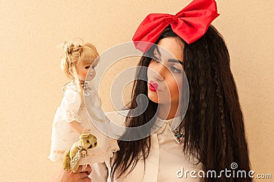 Beautiful woman in the image of a doll holding a doll Stock Photo