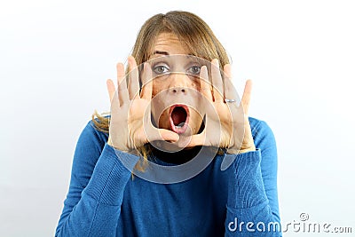 Beautiful woman screams with hands beside mouth looking at camera. Stock Photo