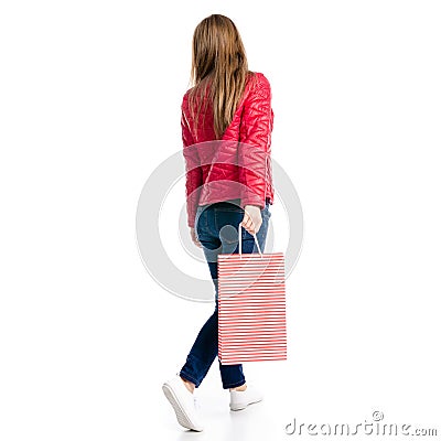 Beautiful woman in jacket and jeans in hand bag package goes Stock Photo