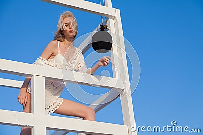 Beautiful fashionable woman lifeguard in white clothes on the beach by the sea Stock Photo