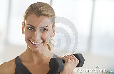 Beautiful Woman Lifting Dumbbell At Health Club Stock Photo