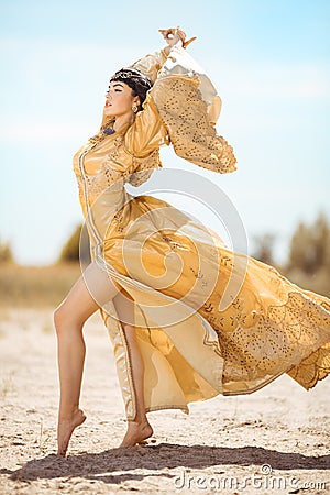 Beautiful woman like Egyptian Queen Cleopatra on in desert outdoor. Stock Photo