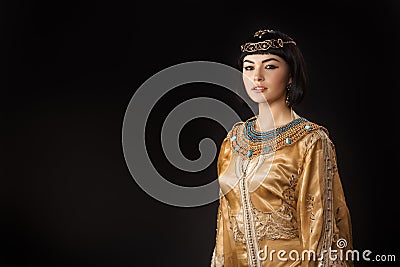 Beautiful woman like Egyptian Queen Cleopatra with serius face against black background Stock Photo