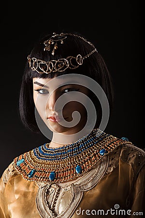 Beautiful woman like Egyptian Queen Cleopatra with serius face on black background Stock Photo