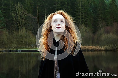 Beautiful Woman with long cascading red hair looking up Stock Photo