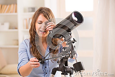 Beautiful woman looking through telescope Stock Photo