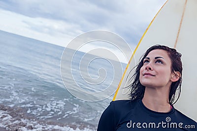 Beautiful woman looking up with surfboard Stock Photo