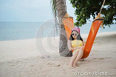 Woman lying on the cradle at the beach Stock Photo