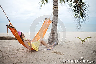 Woman lying on the cradle at the beach Stock Photo