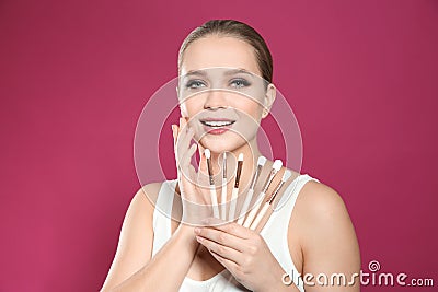 Beautiful woman with makeup brushes on background Stock Photo