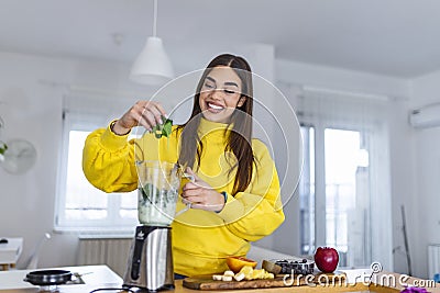 Beautiful woman making fruits smoothies with blender. Healthy eating lifestyle concept. Young woman preparing drink with bananas, Stock Photo