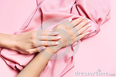 Beautiful woman manicure on creative pink background with silk fabric. Minimalist trend Stock Photo