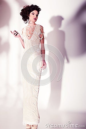 Beautiful woman model posing in elegant pearl dress in the studio Stock Photo