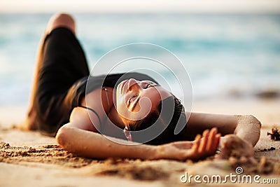 Beautiful woman by the ocean at sunset Stock Photo