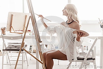 Beautiful woman paints on canvas Stock Photo