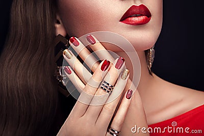 Beautiful woman with perfect make-up and red and golden manicure wearing jewellery Stock Photo