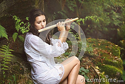 Beautiful woman playing flute after the rain Stock Photo