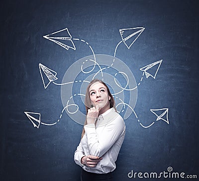 A beautiful woman is pondering about possible solutions of the complicated problem. Many arrows with different directions are draw Stock Photo