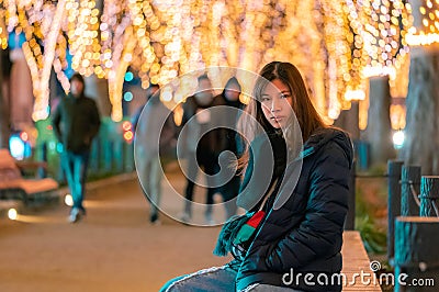 Beautiful Woman in winter clothing at night in The Jozenji christmas light up festival in Sendai, Japan Stock Photo