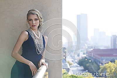 Beautiful woman posing on urban balcony with city view Stock Photo