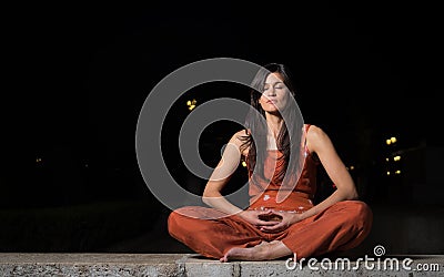 Beautiful woman practicing meditation at night Stock Photo