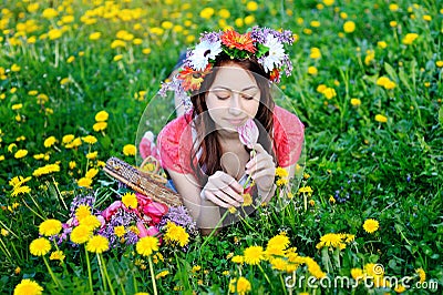 Beautiful woman in a red dress lying on meadow with yellow flowers Stock Photo