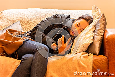 Beautiful woman relaxed using smart phone lying on a sofa in the living room. Stock Photo