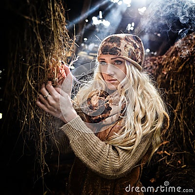 Beautiful woman relaxing in straw in autumn in smoky Stock Photo