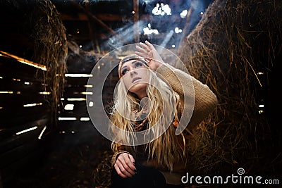 Beautiful woman relaxing in straw in autumn in smoky room Stock Photo