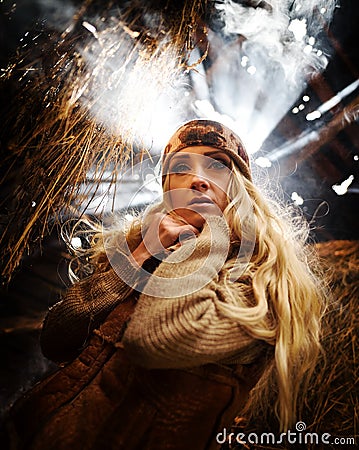 Beautiful woman relaxing in straw in autumn in smoky room Stock Photo